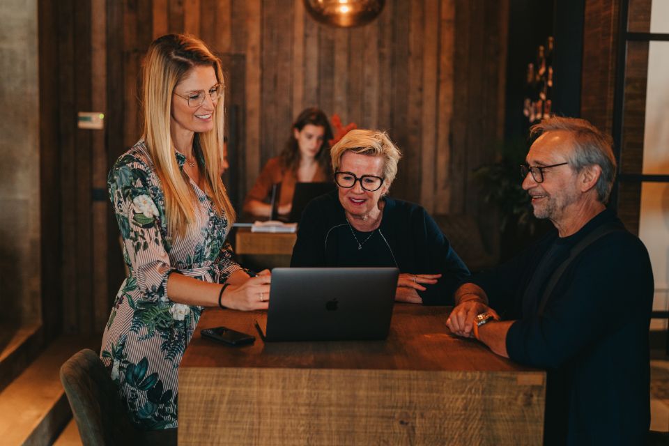 Nele geeft uitleg op laptopscherm aan klanten